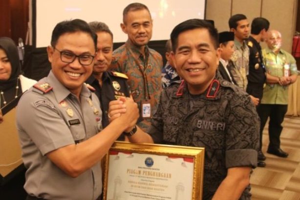 Kepala Kantor Wilayah Kemenkumham Banten, Dodot Adikoeswanto, menerima penghargaan dari Kepala BNN Banten Rohmad Nursahid.