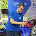 Steffiani Setyadji mendampingi ayahnya, Santoso membagikan beras kepada warta sekitar lokasi outlet Happy Puppy di Jalan Dr Soetomo.
