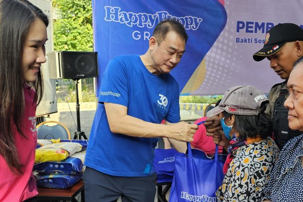 Steffiani Setyadji mendampingi ayahnya, Santoso membagikan beras kepada warta sekitar lokasi outlet Happy Puppy di Jalan Dr Soetomo.