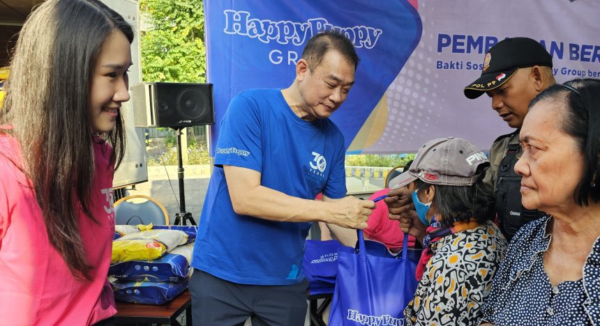 Steffiani Setyadji mendampingi ayahnya, Santoso membagikan beras kepada warta sekitar lokasi outlet Happy Puppy di Jalan Dr Soetomo.