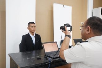 Petugas imigrasi sedang mengambil poto pemohon paspor dinas di Kantor Imigrasi Kelas I Khusus TPI Surabaya.